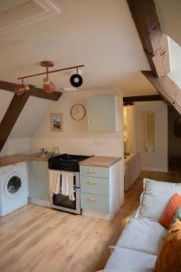 cocina con fogones y sofá en una habitación en Countryside Loft in Bridgnorth en Bridgnorth
