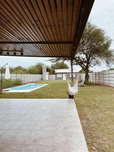 un patio con una hamaca y una piscina en Finca Amankay con alojamiento para 5 personas en Santiago del Estero