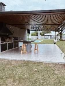 a patio with a table and two stools under a pavilion at Finca Amankay con alojamiento para 5 personas in Santiago del Estero