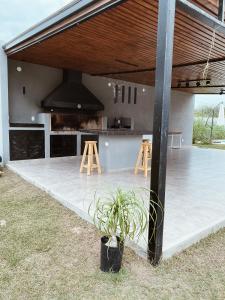an outdoor kitchen with a counter and stools at Finca Amankay con alojamiento para 5 personas in Santiago del Estero
