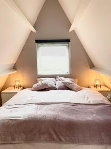 a bedroom with a large bed with a window at La petite maison Durbuy in Durbuy +117 photos