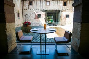 a table and two chairs in a courtyard at Hotel Boutique El Convento de Mave in Santa María de Mave