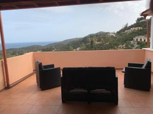 a balcony with chairs and a view of a mountain at Eden Rock House in Domus de Maria +7 photos