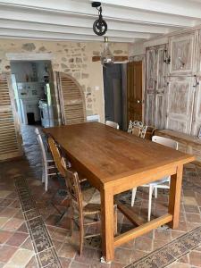 a wooden table with chairs and a dining room at Maison de caractère à Saint-Nectaire le haut in Saint-Nectaire