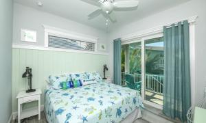 a bedroom with a bed and a ceiling fan at Surfer's Dream, 4 King beds, 4 trundle beds, 6 full baths, pet-friendly with a rooftop deck! in Holmes Beach