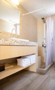 Un baño con lavabo y ducha en Oinopia Apartments, en Aegina Town