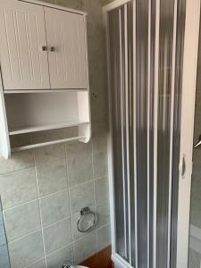 a bathroom with a shower and a white cabinet at Eden Rock House in Domus de Maria