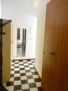 a hallway with a door and a checkered floor at Casa Sweet-lama in Calatabiano