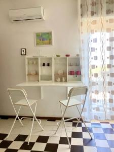 a room with two chairs and a counter with shelves at Casa Sweet-lama in Calatabiano