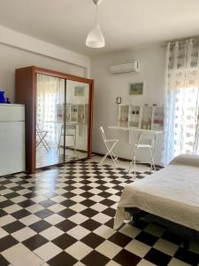 a bedroom with a bed and a checkerboard floor at Casa Sweet-lama in Calatabiano