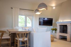 una sala de estar con una mesa y una chimenea en Oinopia Apartments, en Aegina Town