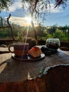uma chávena de café e um bolo numa mesa em La Genoveva Posada entre Viñedos em Villa Unión