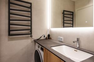 ein Bad mit einem Waschbecken und einem Spiegel in der Unterkunft Apartamentai Monciškės "Čiki puki" in Palanga