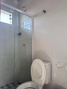 a bathroom with a toilet and a glass shower at Suites do Rafa Ubatuba in Ubatuba