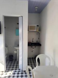 a kitchen with a table and chairs and a microwave at Suites do Rafa Ubatuba in Ubatuba