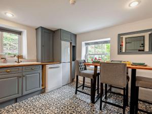 a kitchen with blue cabinets and a table and chairs at 2 Bed in Brigsteer 94582 in Brigsteer