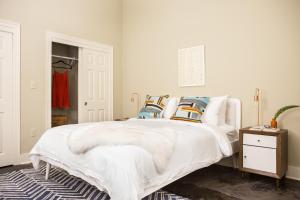 a bedroom with a white bed with pillows on it at The Bywater in New Orleans