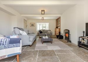 a living room with two couches and a fireplace at Fig Tree Cottage - Corfe Castle in Corfe Castle