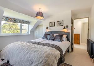 a bedroom with a large bed and a window at Fig Tree Cottage - Corfe Castle in Corfe Castle