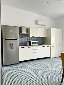 eine Küche mit weißen Schränken und einem Kühlschrank in der Unterkunft Apartamento en Casco Viejo de Panamá in Panama-Stadt