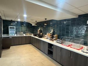 a large kitchen with blue tiles on the wall at La Quinta Inn by Wyndham Albuquerque Airport in Albuquerque