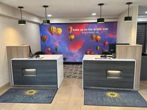 a lobby with two desks and a wall with balloons at La Quinta Inn by Wyndham Albuquerque Airport in Albuquerque