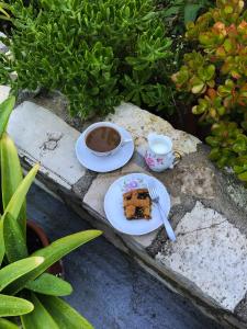 un plato con un trozo de pastel y una taza de café en Sunflower Himara, en Himare