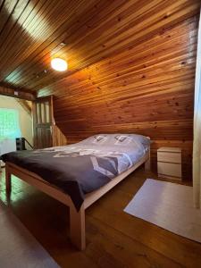 - une chambre avec un lit dans une cabane en bois dans l'établissement Ljubav Stara Zaovine, à Lazići