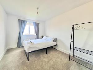 a white bedroom with a bed and a window at Roman Way Getaway- West Midlands in Wednesbury