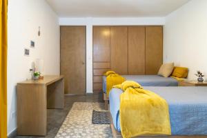 1 dormitorio con 2 camas y mantas amarillas en CASa SENECA en La Paz