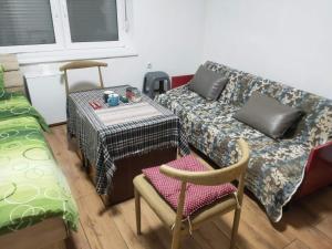 a living room with a couch and a table and chairs at Cozy hotel with breakfast in Subotica