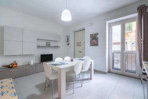 uma cozinha e sala de jantar com uma mesa branca e cadeiras em Casa Carlotta em Noto
