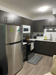 a kitchen with a stainless steel refrigerator and microwave at Exquisite Guest suite in Saskatoon in Saskatoon