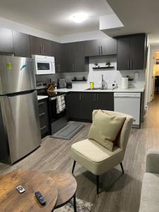 a kitchen with a refrigerator and a chair and a table at Exquisite Guest suite in Saskatoon in Saskatoon