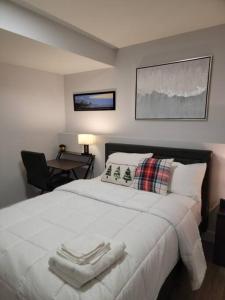 1 dormitorio con 1 cama blanca grande y 1 silla en Exquisite Guest suite in Saskatoon en Saskatoon