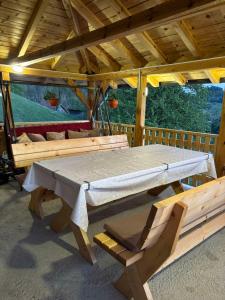 - une grande table et des chaises en bois dans un pavillon dans l'établissement Ljubav Stara Zaovine, à Lazići