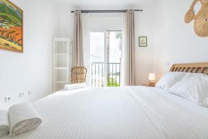 ein weißes Schlafzimmer mit einem großen Bett und einem Fenster in der Unterkunft La Cala de Mijas Miraflores in Mijas