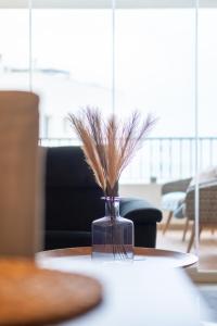 Eine Vase mit Gras auf dem Tisch. in der Unterkunft La Cala de Mijas Miraflores in Mijas