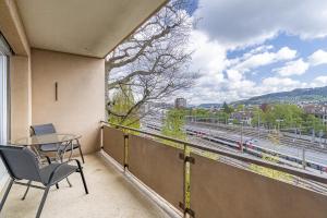 a balcony with a table and chairs and a view of a train at Möblierte Zimmer - gratis Parkplatz in Bern