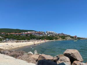 a beach with a group of people in the water at VODENICATA 7 Apartment Sveti Vlas in Sveti Vlas