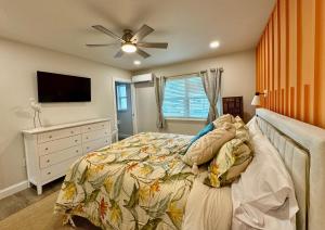 a bedroom with a bed and a flat screen tv at Bird of Paradise - 544A in Sarasota