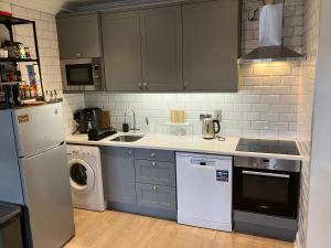 都柏林的住宿－Dorset Street Upper，厨房配有灰色橱柜、洗衣机和烘干机