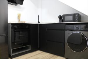 uma cozinha preta com um micro-ondas e uma máquina de lavar louça em Las Arenas Suites 2 em Valência
