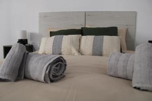 uma grande cama branca com almofadas em cima em Las Arenas Suites 2 em Valência