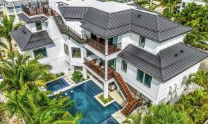 una vista aérea de una casa con piscina en Swanky Bubbles, 9 beds, 11 bathrooms, pet-friendly with a rooftop deck and steps away to the beach! en Holmes Beach