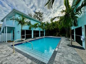 una piscina frente a una casa azul en Frangipani - 544F, en Sarasota