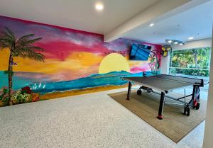 una mesa de ping pong en una habitación con un mural en Frangipani - 544F, en Sarasota