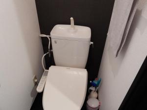 een toilet met een kaars erop in de badkamer bij クレインネスト201貸切9人部屋民泊 海遊館2分、USJ25分無料駐車場 in Osaka