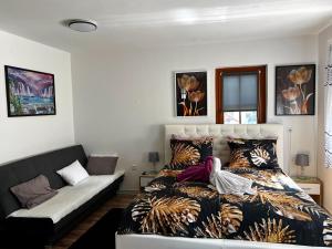 a bedroom with a bed and a couch at Apartma ANAYA in Bovec
