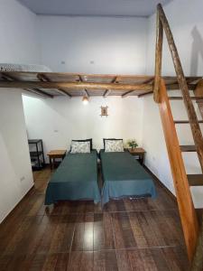 sypialnia z 2 łóżkami w pokoju z drewnianą podłogą w obiekcie Vila do Surfe w mieście Ubatuba